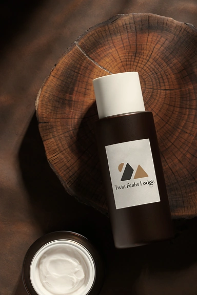 Spa product bottle and cream on wooden surface with Twin Peaks Lodge branding